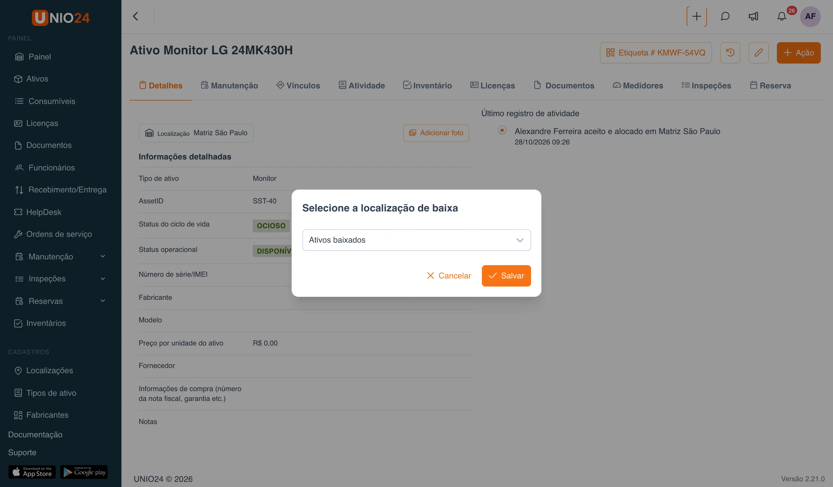 Janela “Selecione a localização de baixa” sobre a ficha de um monitor: campo com a localização “Ativos baixados” e os botões “Cancelar” e “Salvar”