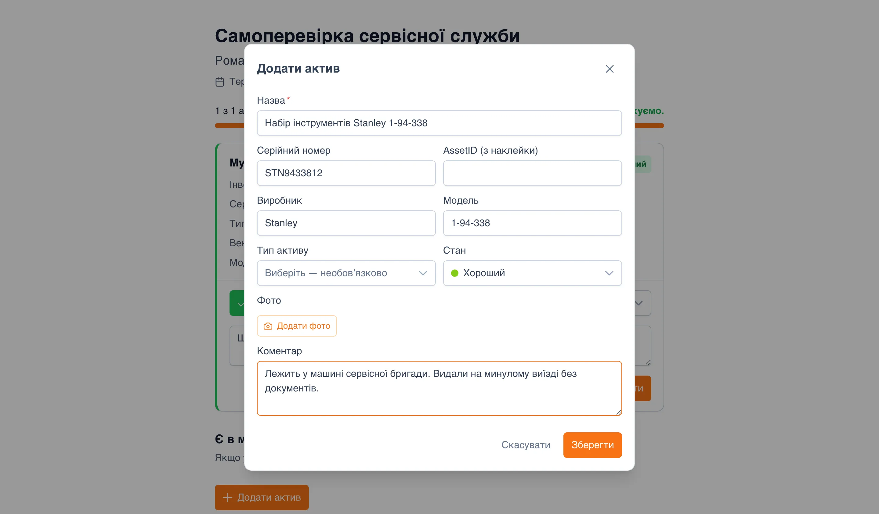 Вікно «Додати актив» поверх сторінки інвентаризації: «Назва» — «Набір інструментів Stanley 1-94-338», «Серійний номер» — «STN9433812», «AssetID (з наклейки)» порожнє, «Виробник» — «Stanley», «Модель» — «1-94-338», «Тип активу», «Стан» — «Хороший», кнопка «Додати фото», «Коментар» — «Лежить у машині сервісної бригади. Видали на минулому виїзді без документів.», кнопки «Скасувати» і «Зберегти»