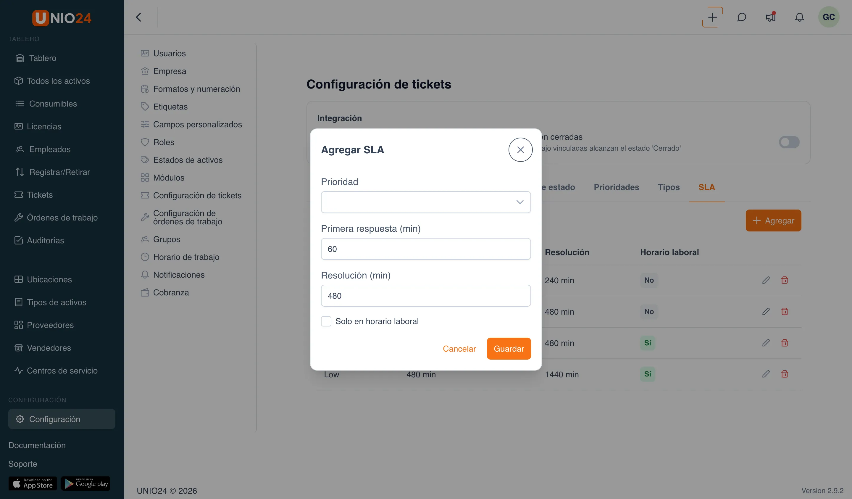 la pestaña «SLA» de la página «Configuración de tickets» con la ventana «Agregar SLA» abierta: los campos «Prioridad», «Primera respuesta (min)», «Resolución (min)» y la casilla «Solo en horario laboral»; de fondo una tabla de políticas de SLA por prioridad